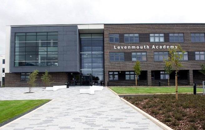 he exterior of Levenmouth Academy, a modern building with a mix of dark brick and large glass windows. he exterior of Levenmouth Academy, a modern building with a mix of dark brick and large glass windows.